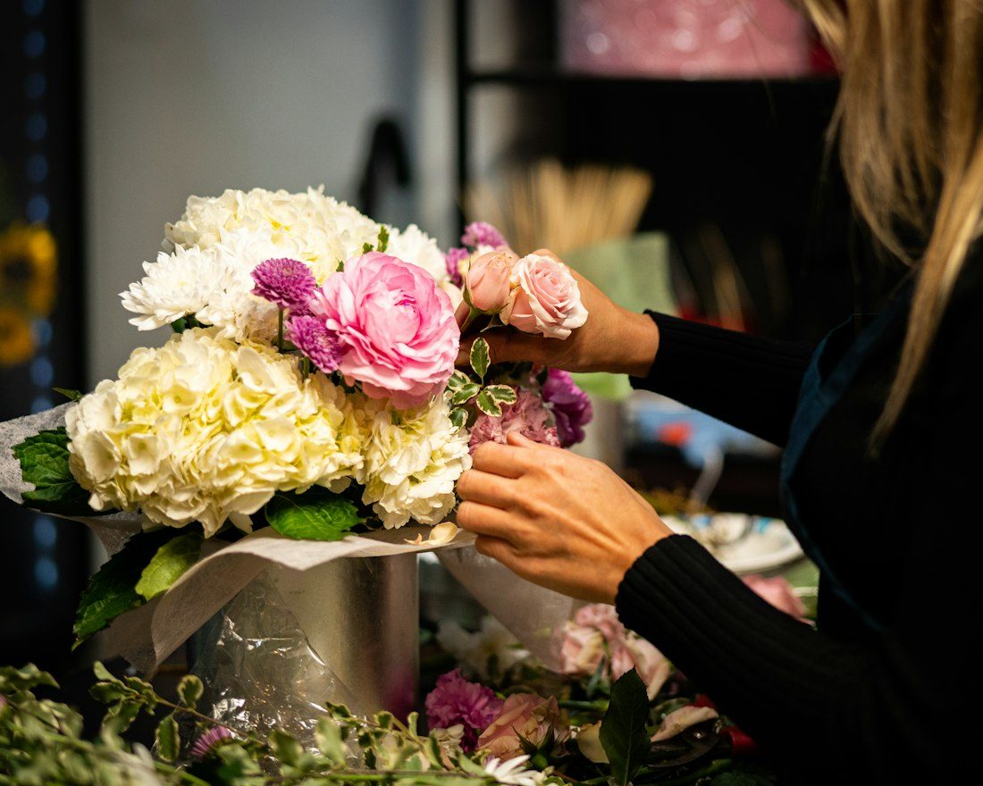 A florist hand-tying a bouquet